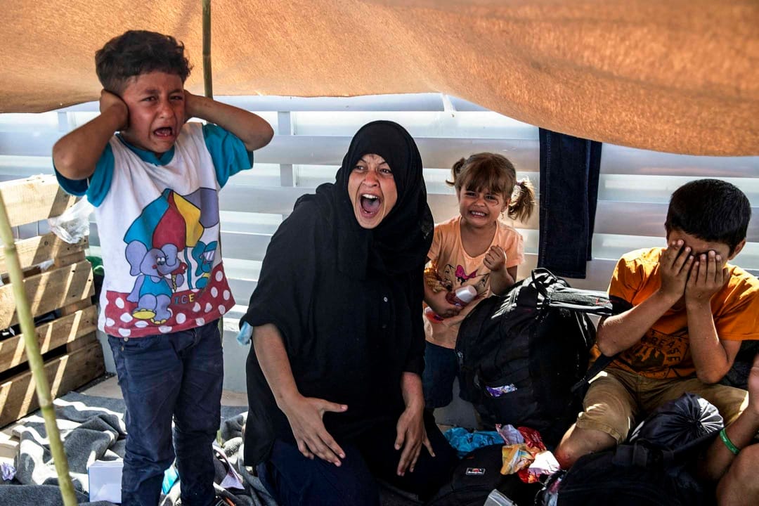 2020年9月12日,希臘萊斯沃斯島,逃離莫里亞難民營火災的難民與當地警方對峙,一名女子與孩子們在旁痛哭。