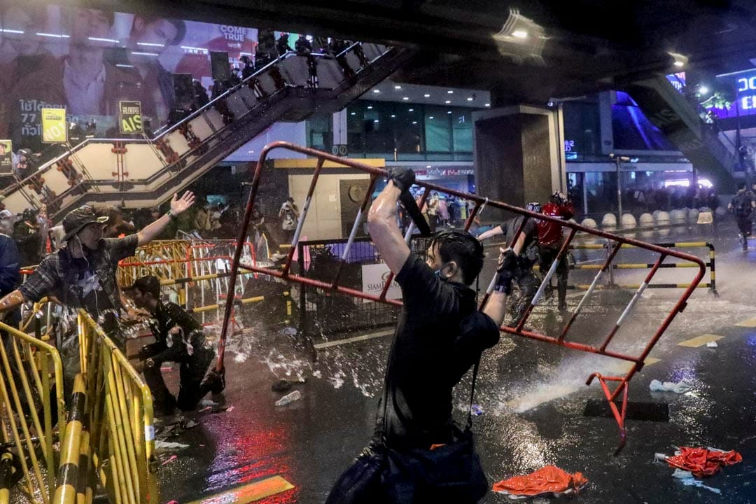 2020年10月16日泰国曼谷,一位示威者在抗议中举起路障。