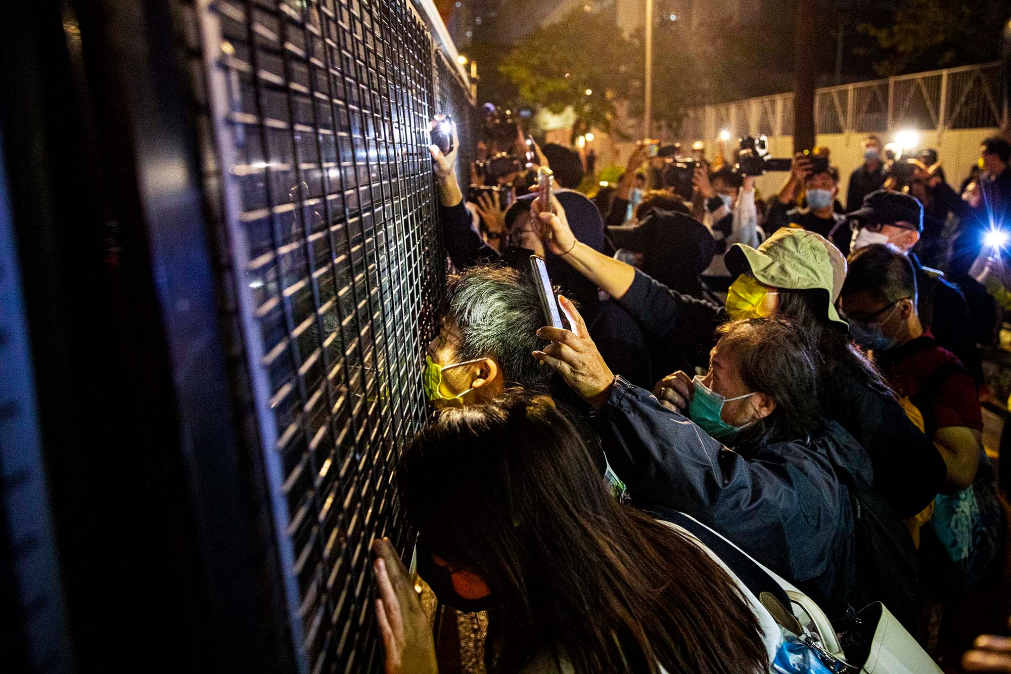 2020年12月2日,西九龍裁判法院,法庭外的支持者送別被判入獄的周庭、黃之鋒、林朗彥和其他因反修例運動而入獄的示威者,拍打一架囚車的車窗。