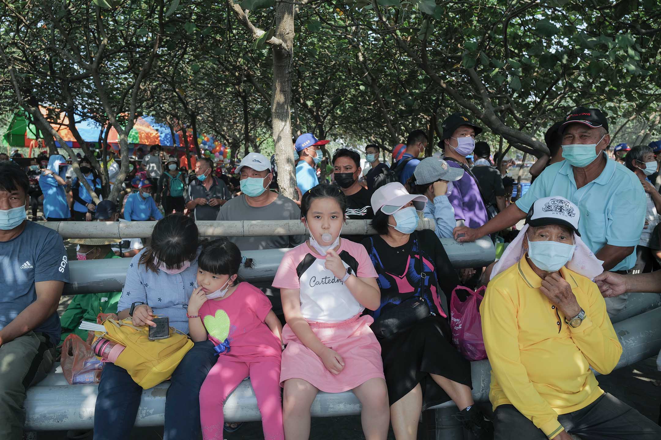 2021年10月24日屏東東港,等待“請水”的民眾在樹蔭下休息。