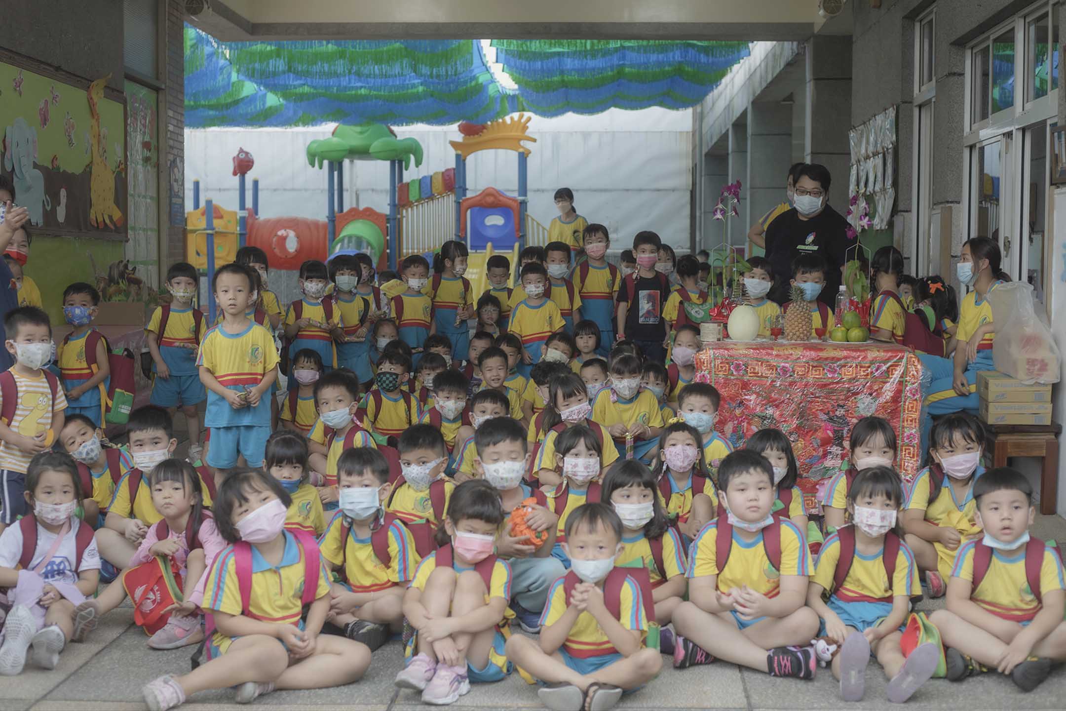 2021年10月25日東港,幼兒園學生等待放學,學校門前放上祭品。