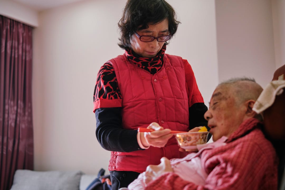 洗浴過後的下午,朱和珍喂母親陳菊清吃水果和點心。