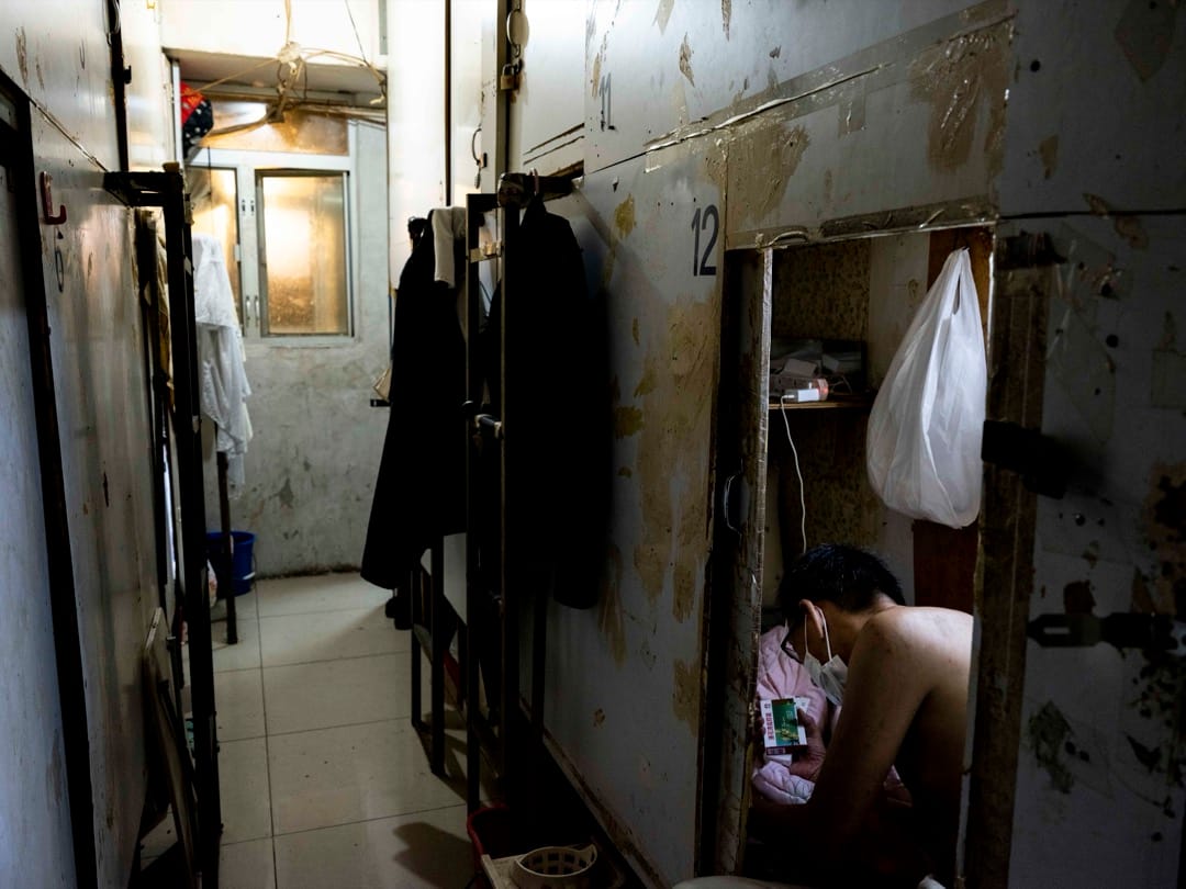 2022年6月23日，疫情期間，深水埗一間棺材房住戶正在查看連花清瘟膠囊。攝：林振東/端傳媒