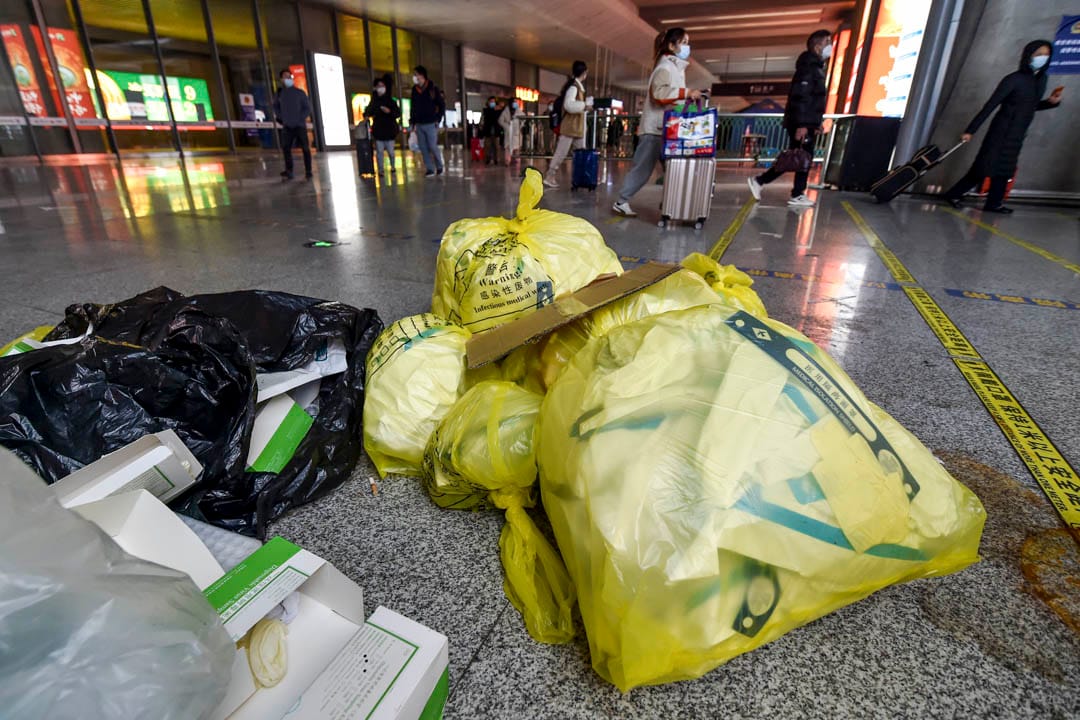 2022年12月7日,中國南京,高鐵南京南站內的乘客走過暫放在地上的醫療廢料。