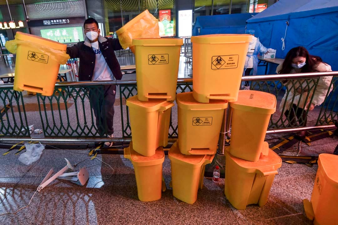 2022年12月7日,中國南京,工作人員在清理高鐵南京南站內的醫療廢料桶。