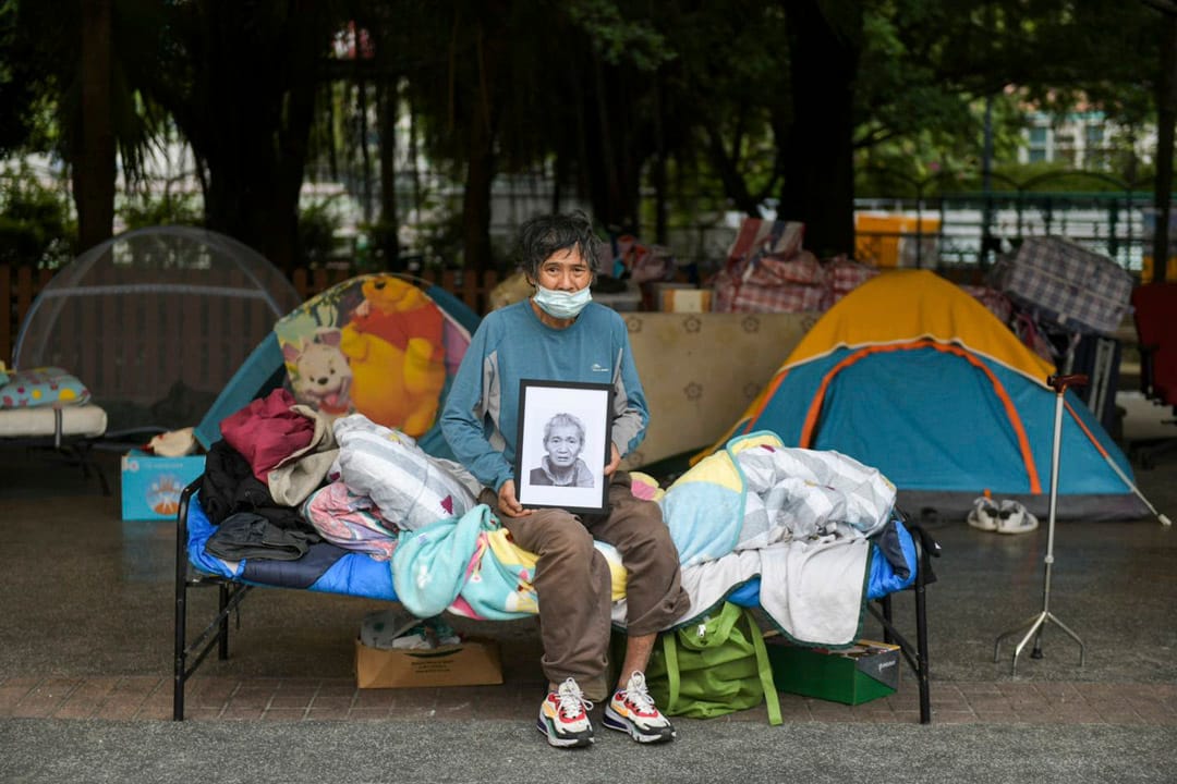 2022年3月31日 無家者周雄光手執「表哥」馬月榮遺照。馬月榮不幸於無家者告政府案裁決前病逝，無緣見證勝訴時刻。