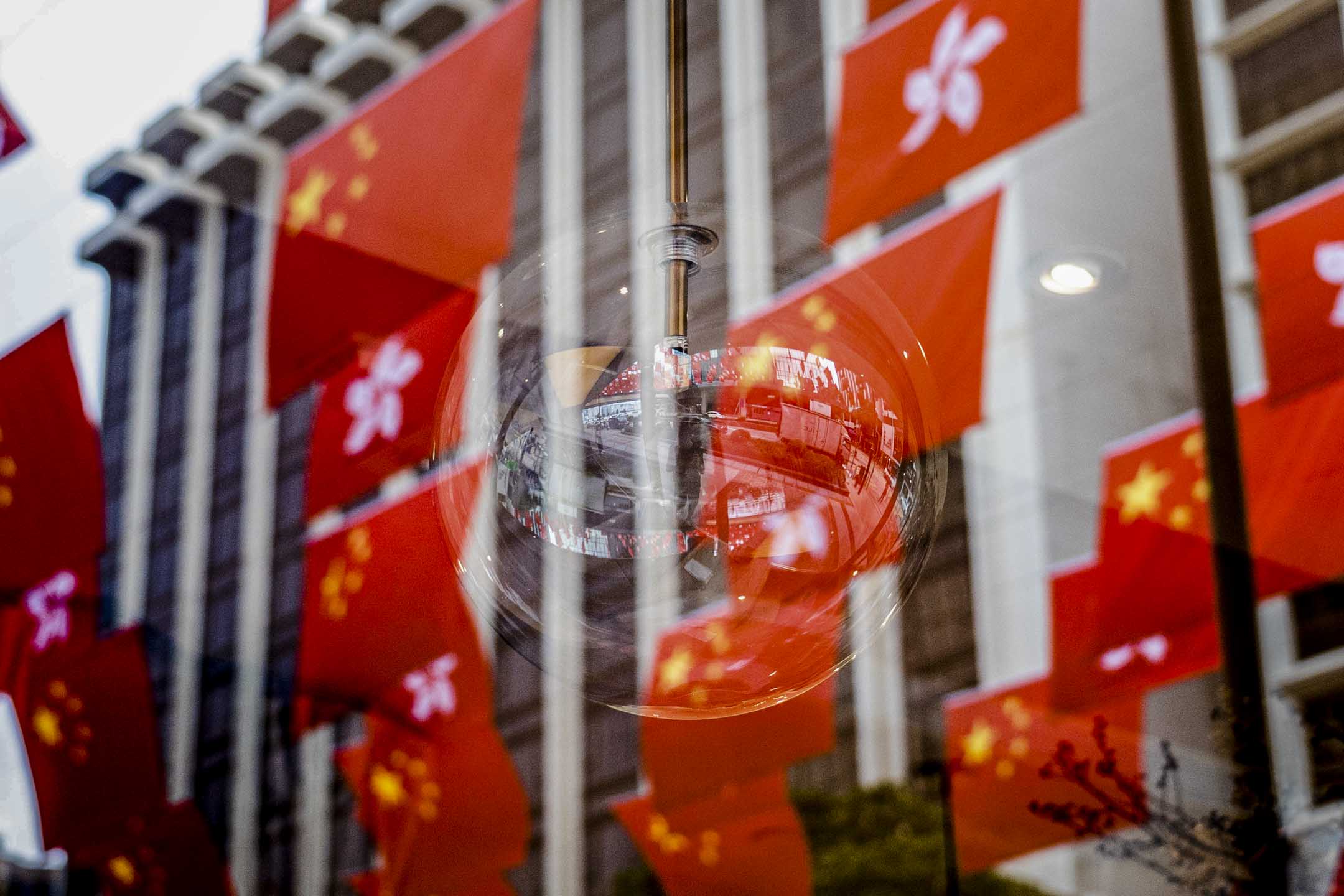 2023年6月30日,尖沙咀中心外,挂满过百面国旗及区旗。摄:Ryan Lai/端传媒