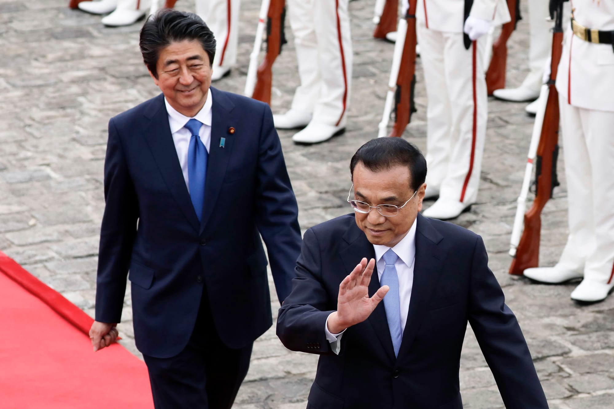 2018年5月9日，日本東京，中國國務院總理李克強與日本首相安倍晉三檢閱儀仗隊時向客人揮手致意。攝：Kiyoshi Ota/Bloomberg via Getty Images
