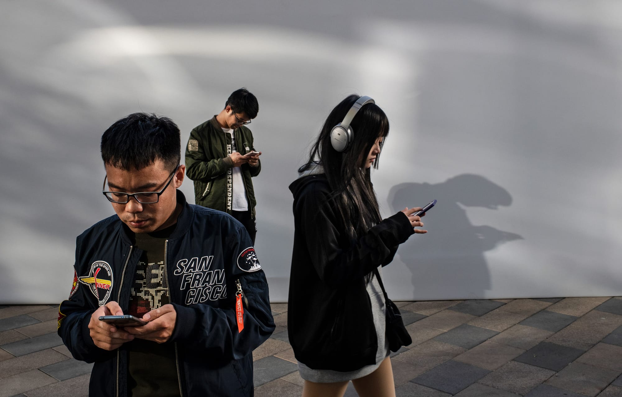 2019年10月31日,中國北京,市民在街道上手機。攝:Kevin Frayer/Getty Images