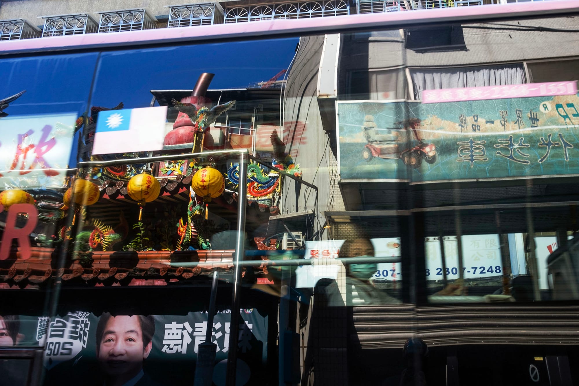 2023年11月22日，台北，一架公车经过民进党候选人赖清德的竞选海报。摄：陈焯煇/端传媒