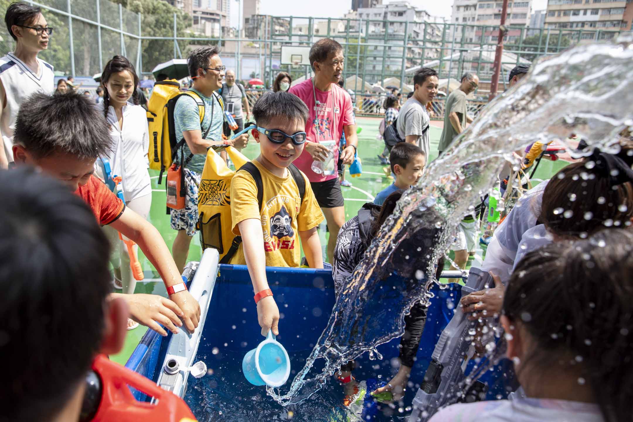2024年4月13日,九龙城的泼水节从城南道移师至贾炳达道公园篮球场举办。摄:林振东/端传媒