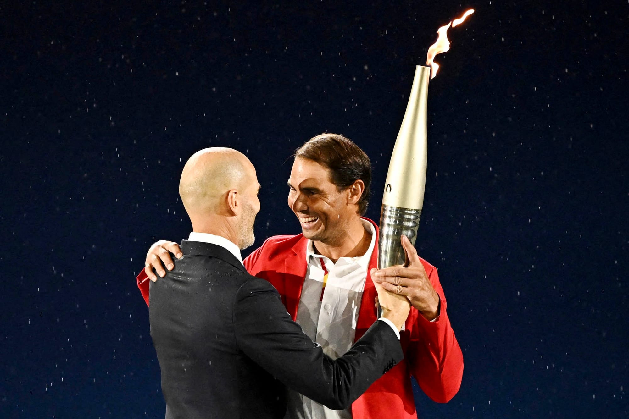 2024年7月26日，法國足球名宿施丹將火炬傳給網球名將拿度。攝：Dylan Martinez/Reuters/達志影像