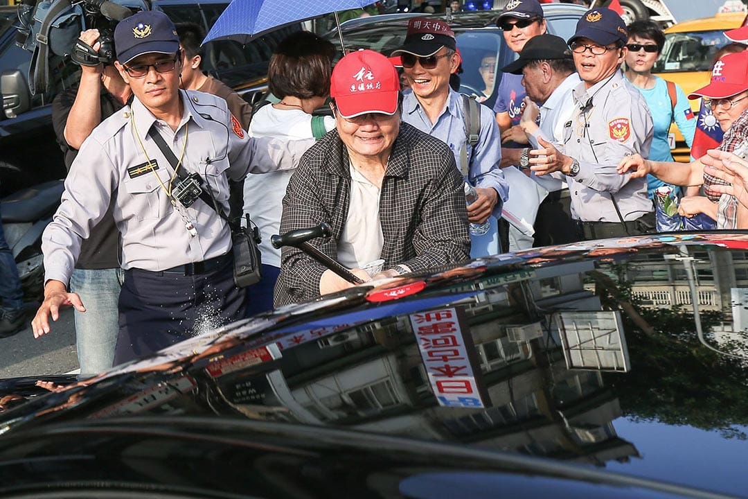 民众持棍棒砸从党中央駚出的车辆。摄 : 张国耀/端传媒