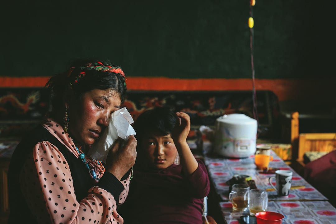 索加鄉移民村村民想起在地震中失去的親人不禁落淚。攝 : 王嘉豪/端傳媒