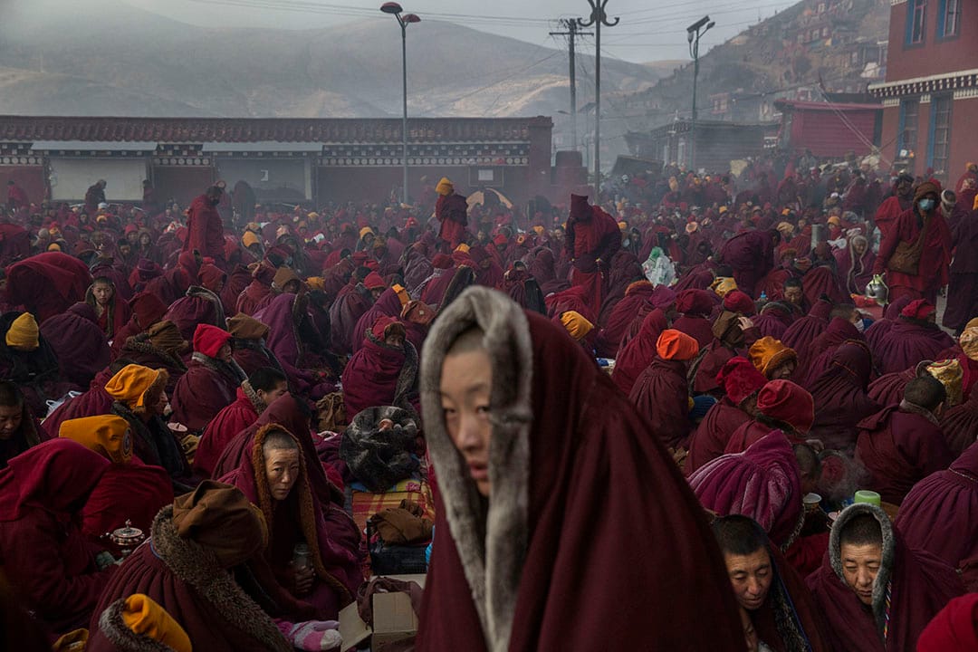 天氣寒冷,喇嘛們披著厚厚的上衣,在佛學院裡坐著。攝:Kevin Frayer/Getty Images