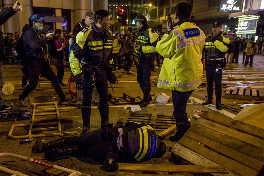  2016年2月9日凌晨二时，旺角，一名警察在亚皆老街倒地。摄：Billy H.C. Kwok/端传媒