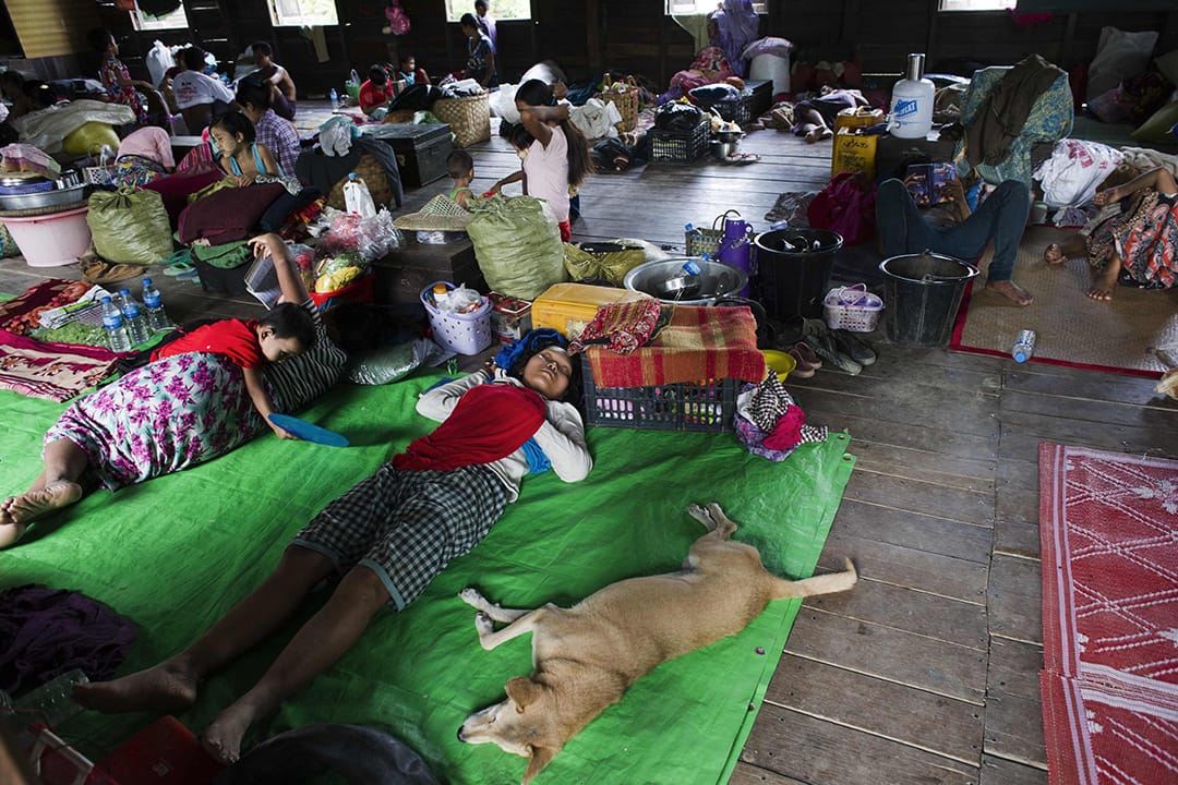 灾民在避难中心避雨。摄: Ye Aung THU/AFP