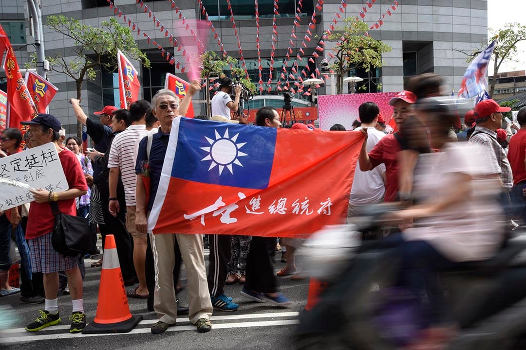 一名支持洪秀柱的民众在国民党中央党部外拿着支持洪秀柱的旗帜。摄 : 陈弘岱/端传媒