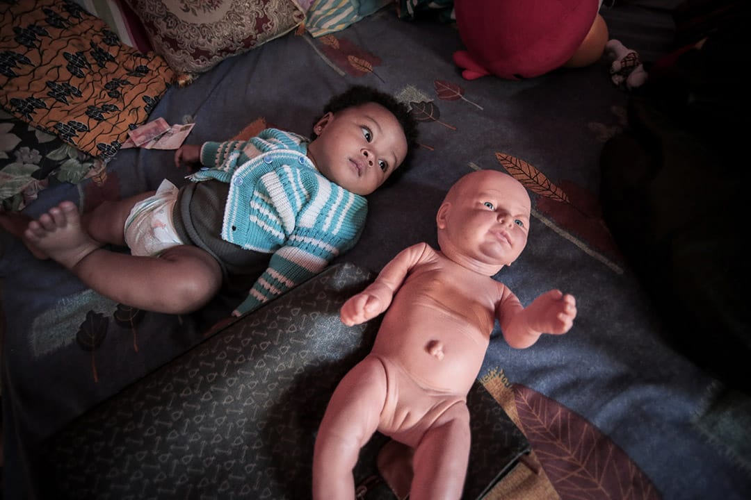 2013年，一位印尼與尼日利亞尋求庇護者的孩子，伴隨著她的是一個人形娃娃。攝: Billy H.C. Kwok/ 端傳媒