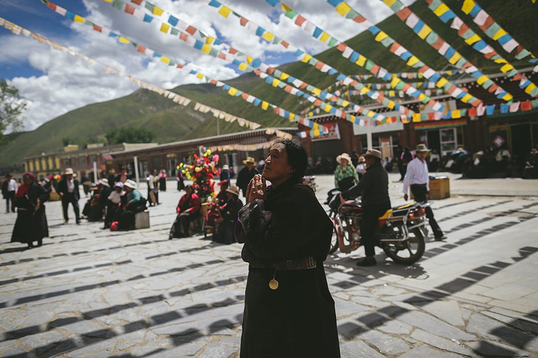 一名到藏族信徒在新砦嘉那嘛呢石堆祈福許願。攝 : 王嘉豪/端傳媒