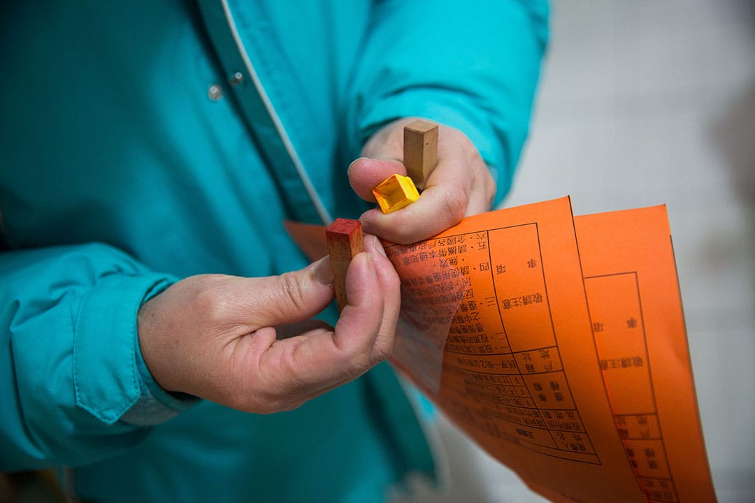 投票当天,谢素嬉拿着印章与通知单到投票站。摄:Billy H.C. Kwok/端传媒