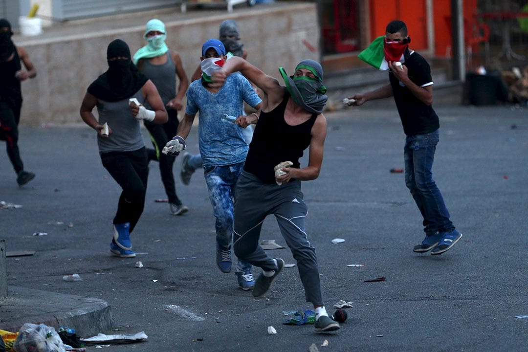 2015年9月30日，約旦河西岸，巴勒斯坦示威者向以色列保安部隊投擲雜物。攝：Mohamad Torokman/REUTERS