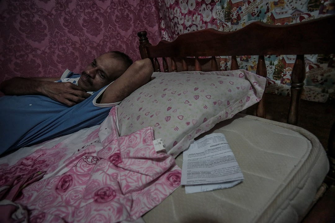 2013年，一位尋求庇護者在家中休息。香港的尋求庇護者持有的是一紙臨時身份證明，他說，「行街紙」和住屋租約會長期隨身攜帶，睡覺時則會放在枕頭下，兩紙證明對於自己來說尤其重要。攝: Billy H.C. Kwok/ 端傳媒