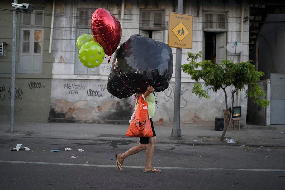 在巴西里约热内卢,一个女人在嘉年华后,带着气球离开。摄:Leo Correa/AP Photo