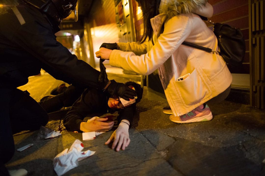 2016年2月9日凌晨二时，旺角，一名示威者头部受伤倒卧地上。摄：林亦非/端传媒