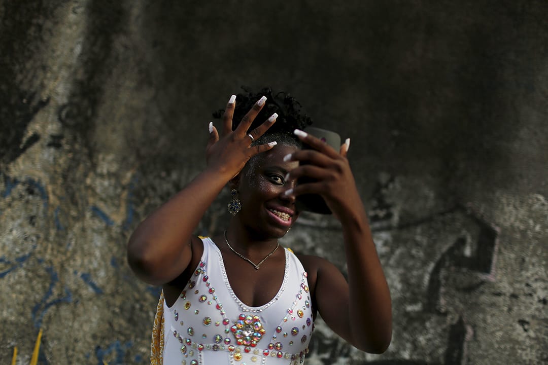 在里约热内卢,一位表演者在狂欢节前化妆。摄:Pilar Olivares/REUTERS